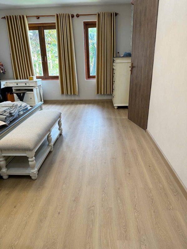 Mặt sàn vân gỗ tạo sự kết nối giữa giường ngủ, hệ tủ và vật liệu hoàn thiện trong phòng Master.